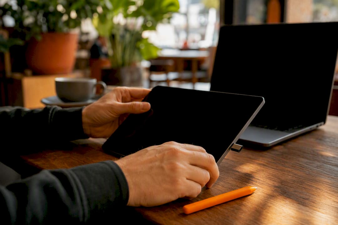 Hands plugging USB drive near laptop
