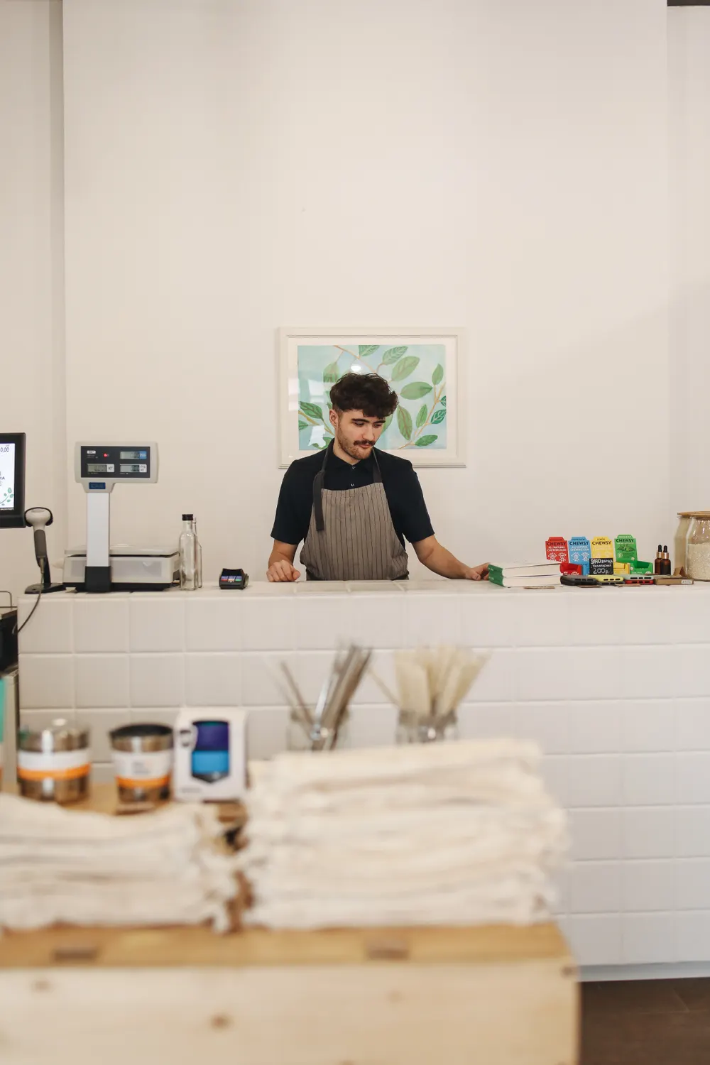 Shopkeeper working behind a small shop counter